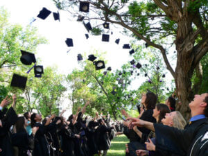 graduates tossing caps into the air