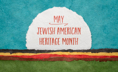 Jewish American Heritage Month graphic: handwriting on a round sheet of watercolor paper against abstract landscape