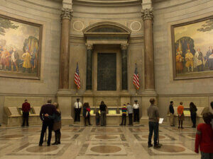interior photo of NARA rotunda with about a dozen visitors