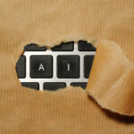 laptop keyboard buttons for "a" and "i" revealed by torn brown paper pulled away from where the paper covers the rest of the keyboard